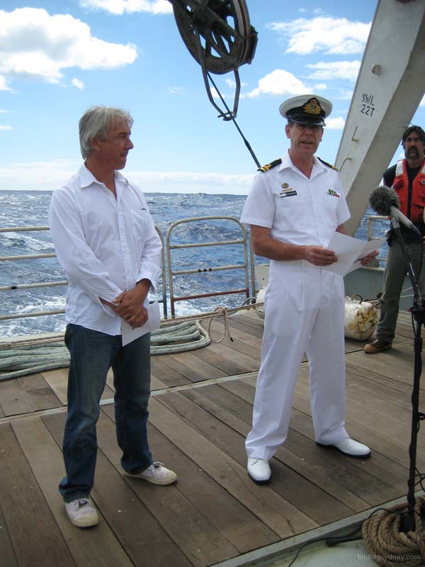 Ullrich Krafzik and John Perryman reading from an order of service document on the deck.