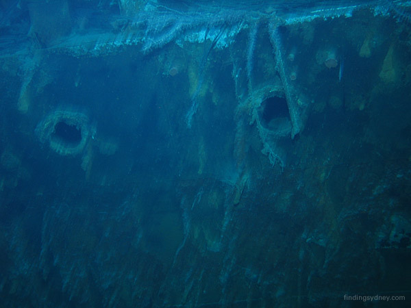 A row of portholes visible along the port side of the HMAS Sydney hull.