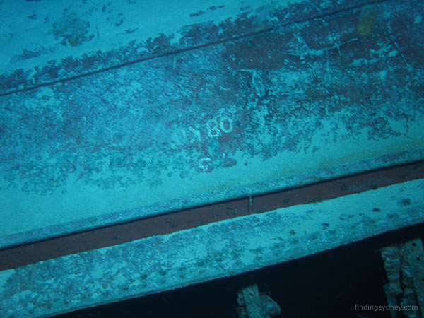 The identification mark '08KO' painted in white on a piece of Kormoran's hull plate beneath the bilge keel.