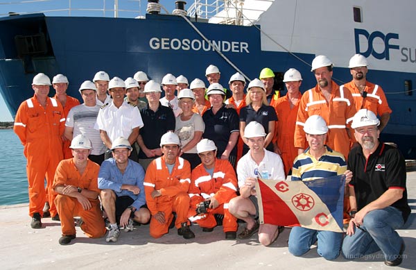 The full expedition team posing for a group photo on the dock in Geraldton with the Geosounder in the background.