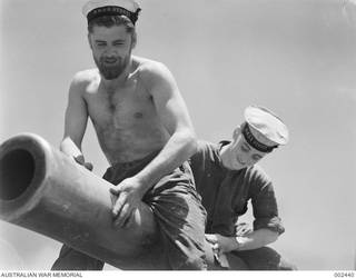 Crew members of HMAS Sydney cleaning guns after the successful action against the Italian cruiser Bartolomeo Colleoni. On the left is Ordinary Seaman - H. McMahon and AB Alexander Harold Doxey. Doxey was later killed in action when the Sydney was sunk with the loss of all hands on 20 November 1941.
