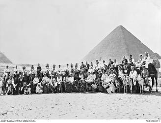 Group portrait of crew members of the RAN ships HMAS Sydney II and HMAS Australia II sitting on camels and donkeys in front of a pyramid. The newly commissioned Sydney in company with HMAS Australia had stopped at Alexandria on her way back to Australia after commissioning and working up trials. On 29 April 1935 the two vessels visited Gallipoli where the crews visited some of the battlefields and Anzac cemeteries. Note the head of the Sphinx at far right. (Donor A. McDonald)