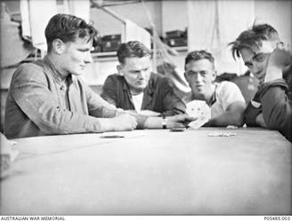 Informal portrait of four men in sitting around a table playing cards at C Block Dormitory at Flinders Naval Depot. The men are, from left to right: 23854 Ordinary Telegraphist Michael Henry Hogan, of Millicent, SA, who was killed in action aboard HMAS Sydney in 1941; Signaller Wagner; Signaller Drury and Signaller Johnstone.