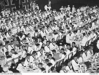 The crew of HMAS Sydney II enjoy a luncheon in Sydney Town Hall after the ceremonial welcome home march through George Street. The ship had returned from service in the Mediterranean. Identified is 23464 Able Seaman (AB) Martin Curtis James, of Newcastle, NSW, front table second from right, left side of table, second from table end. On 19 November 1941 the Sydney was sunk in the Indian Ocean off the coast of Western Australia by the German auxiliary cruiser Kormoran. All 645 crew members aboard HMAS Sydney were lost.