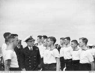 CAPTAIN (CAPT) JOHN COLLINS, RAN, INSPECTING CREW MEMBERS ABOARD HMAS SYDNEY II. CAPT COLLINS IS LOOKING AT S/4086 ABLE SEAMAN BERNARD ALBERT DIEWS.