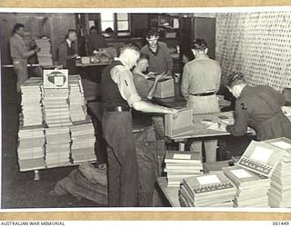 SYDNEY, NSW. 1943-12-10. DESPATCH SECTION OF MILITARY HISTORY SUBSECTION AT THE SHOWGROUND WHERE PERSONNEL CAN BE SEEN PREPARING COPIES OF AUSTRALIAN WAR MEMORIAL PUBLICATIONS "KHAKI AND GREEN" AND "HMAS MARK II" FOR DESPATCH TO MEMBERS OF THE SERVICES. IDENTIFIED PERSONNEL ARE: LANCE CORPORAL A. L. ISHERWOOD (1); GUNNER PLUNKETT (2).
