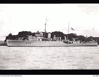SYDNEY, NSW. 1941. PORT SIDE VIEW OF THE SLOOP HMAS SWAN (II) (U74). HER ORIGINAL ARMAMENT OF THREE 4 INCH MARK V GUNS ON MARK III HIGH ANGLE MOUNTINGS AND A QUADRUPLE .5 INCH VICKERS MACHINE GUN MOUNTING ON A BANDSTAND AMIDSHIPS. MINESWEEPING KITE/OTTERS ARE ON THE QUARTERDECK. (NAVAL HISTORICAL COLLECTION)