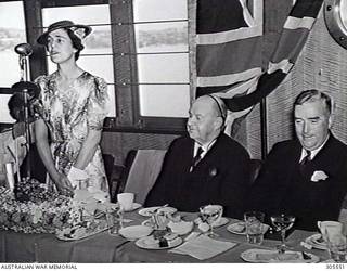 SYDNEY, NSW. MRS R. G. MENZIES, WIFE OF THE PRIME MINISTER AND LAUNCHING LADY, SPEAKING, SIR GEORGE DAVIS KT, CHAIRMAN OF DIRECTORS, COCKATOO DOCK AND ENGINEERING COY PTY LTD AND THE PRIME MINISTER, MR R. G. MENZIES (RIGHT) AT THE LUNCHEON PARTY AFTER THE LAUNCHING OF ESCORT SLOOP HMAS WARREGO (II). (NAVAL HISTORICAL COLLECTION).