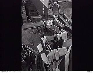 COCKATOO ISLAND DOCKYARD, SYDNEY, NSW. 1940-02-10. MRS R. G. MENZIES, WIFE OF THE PRIME MINISTER, LAUNCHES THE ESCORT SLOOP HMAS WARREGO (II) BY SMASHING THE TRADITIONAL BOTTLE OF CHAMPAGNE AGAINST ITS BOWS. (NAVAL HISTORICAL COLLECTION).