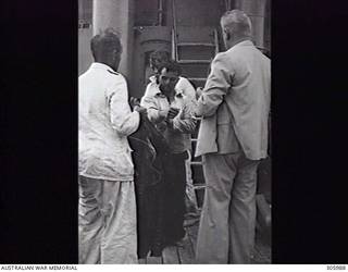 INDIAN OCEAN. 1941-11-25. SURVIVORS FROM THE GERMAN AUXILARY CRUISER KORMORAN, WHICH SANK AND WAS SUNK BY HMAS SYDNEY (II), RECEIVE DRY CLOTHING ABOARD THE MERCHANT VESSEL CENTAUR. (NAVAL HISTORICAL COLLECTION).