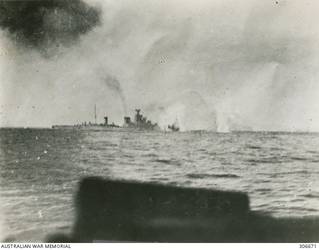 STOPPED AND ON FIRE AFTER THE ACTION OFF CAPE SPADA WITH HMAS SYDNEY (II) AND BRITISH DESTROYERS THE ITALIAN CRUISER BARTOLOMEO COLLEONI IS SURROUNDED BY SHELL SPLASHES AS SHE AWAITS THE COUP DE GRACE. (NAVAL HISTORICAL COLLECTION).
