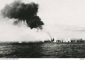 STOPPED AND ON FIRE AFTER THE ACTION OFF CAPE SPADA WITH HMAS SYDNEY (II) THE ITALIAN CRUISER BARTOLOMEO COLLEONI IS SURROUNDED BY SHELL SPLASHES. THE SMOKE FROM HER FORE FUNNEL IS CAUSED BY THE HIT TO THE BOILER ROOM THAT STOPPED HER. (NAVAL HISTORICAL COLLECTION).