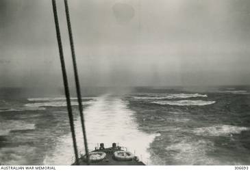EDDIES LEFT IN THE WATER BY BOMBS DROPPED FROM THREE ENEMY AIRCRAFT OFF THE STERN OF THE CRUISER HMAS SYDNEY (II) AS SHE RETURNED TO PORT AFTER SINKING THE ITALIAN CRUISER BARTOLOMEO COLLEONI IN THE ACTION OFF CAPE SPADA. NOTE THE CARLEY RAFTS (FLOATS) ON THE QUARTERDECK. (NAVAL HISTORICAL COLLECTION).