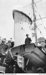 Unidentified Australian sailors inspecting the damage caused to the light cruiser HMAS Sydney II, after the forward funnel was struck by a shell fired from the Italian cruiser Bartolomeo Colleoni during a naval battle off Cape Spada, Crete. The starboard side of the funnel is seen here which has been peppered with dozens of shell fragments. The Italian ship was immobilised by accurate fire from the Sydney's six inch guns and then sunk by torpedo's launched from the escorting British destroyers.