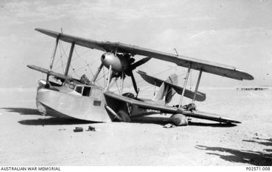 A No 9 Squadron, RAAF, Seagull V (Walrus) amphibian, which was launched from the light cruiser, HMAS Sydney II, to assist in coordinating the cruiser’s bombardment of Bardia on 21 June 1940. The aircraft was shot down by Italian fighters whilst conducting a reconnaissance of the Bardia area. Through the skill of the pilot, 172 Flight Lieutenant Thomas Macbride Price, he managed to crash land the aircraft behind friendly lines in at Mersa Matruh, Egypt, with no injuries to himself or his crew.