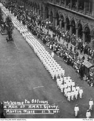 A large crowd of onlookers watch and applaud officers and men of HMAS Sydney II during a ceremonial welcome home march through Martin Place. The crew later enjoyed a luncheon in Sydney Town Hall. The ship had returned from a successful campaign in the Mediterranean. On 19 November 1941 the Sydney was sunk in the Indian Ocean off the coast of Western Australia by the German auxiliary cruiser Kormoran. All 645 crew members aboard HMAS Sydney were lost.