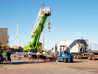Crane being positioned to lift a sea container