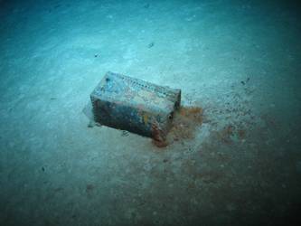 Rectangular riveted steel box on seabed