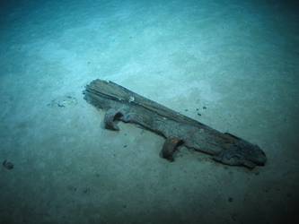Wooden post with metal hinges. Possibly rudder post from boat