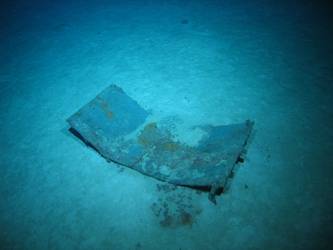 Flat metal rectangular wreckage on seabed